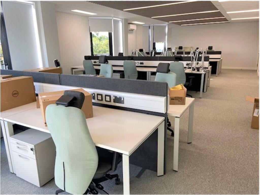 Image of new office with three double rows of desks and office chairs