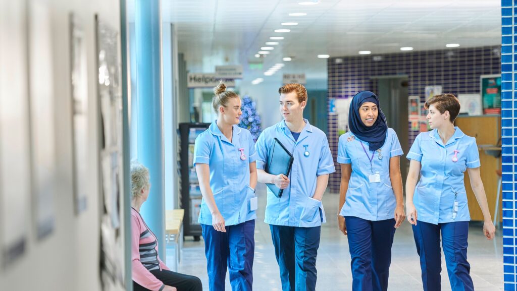 A group of nurses walking down a hospital corridor 