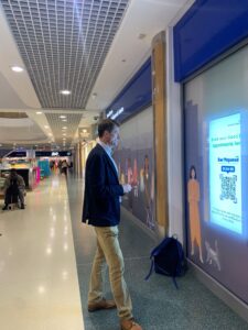 Matthew Taylor looking at a large NHS screen in a shopping centre