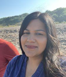 Karina Sale, Engagement Manager, woman with long, dark hair and blue top smiles at camera.