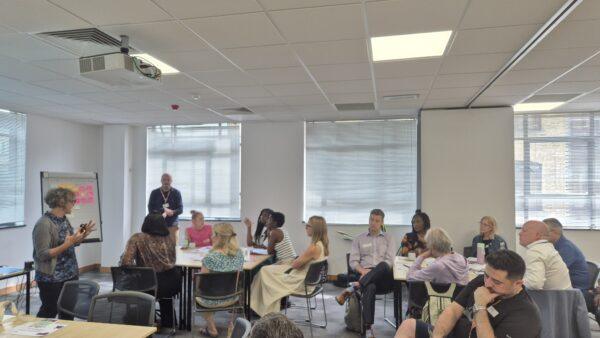 Room of people listening to Amy Bowen talking at first Community Advisory Group for Neighbourhood health in NCL