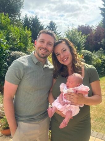 A woman with her partner and baby