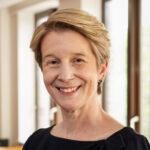 Photo of Amanda Pritchard, woman smiling, windows in background